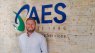AES Gauteng regional manager Jordan Smith standing in front of a company sign for AES
