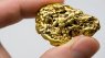 Image of fingers holding a gold nugget