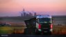 A truck carrying coal with a coal-fired power station in the background