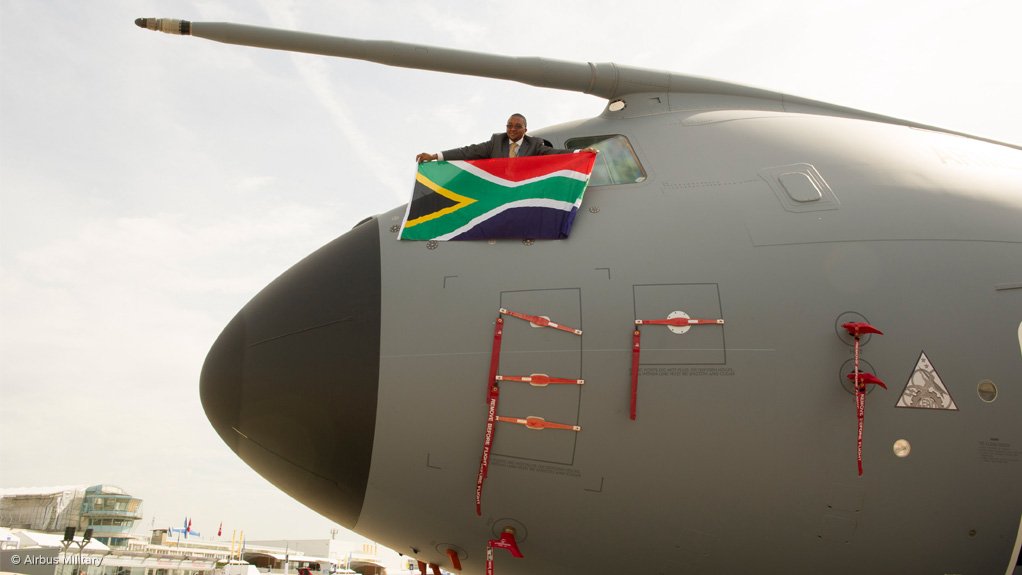 South African Deputy Director General of Public Enterprises Kgathatso Tlhakudi displays a SA flag from the cockpit of an A400M at the Paris Airshow  