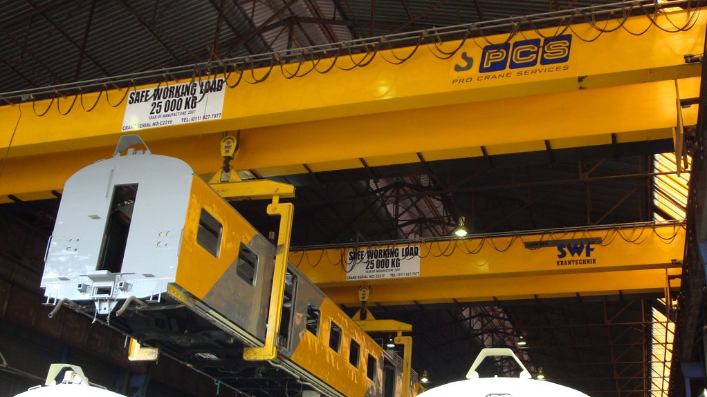 Two 25 t girder cranes in tandem operation loading refurbished coaches for State-owned freight group Transnet