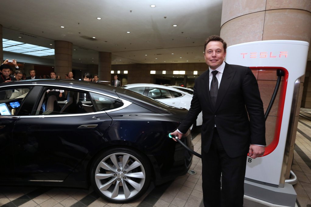 ELECTRIC PARTNERSHIP: Elon Musk, the South African-born cofounder and CEO of Tesla Motors, holds the charging nozzle as he demonstrates the company's Model S electric sedan following a news conference in Tokyo, Japan, in early September. Musk said Tesla might partner with Toyota Motor Corporation again in future.