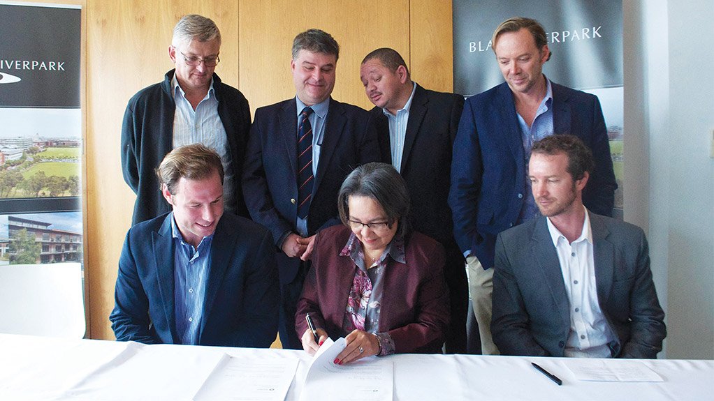 BUSINESS READY Cape Town Mayor Patricia de Lille signs an agreement on solar energy at the Black River Park office development in Observatory, Cape Town, watched by developers and city councillors 