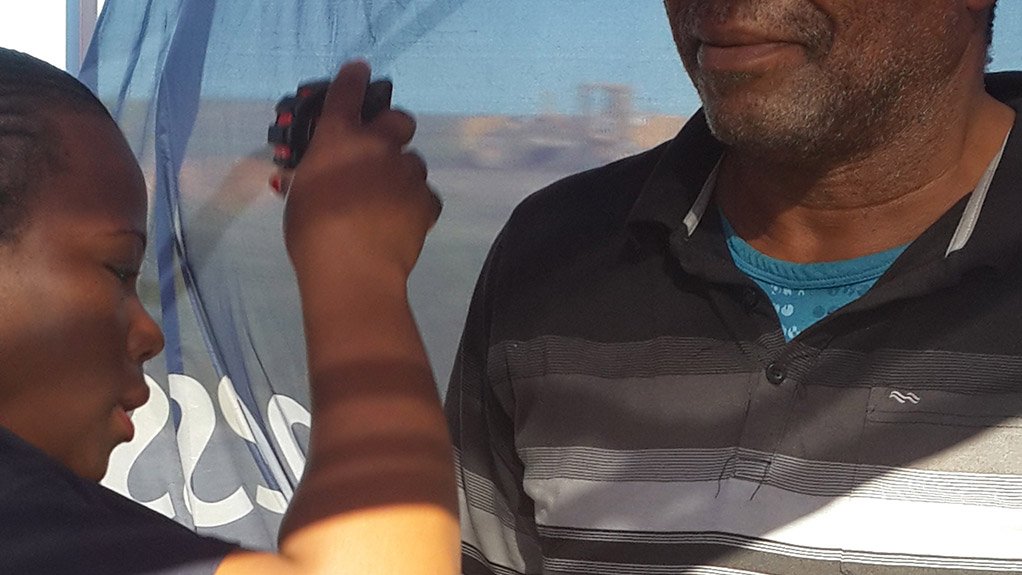 Nurse,-Disebo-Mkhabela,-taking-the-heigh-measurement-of-Trucker,-Headman