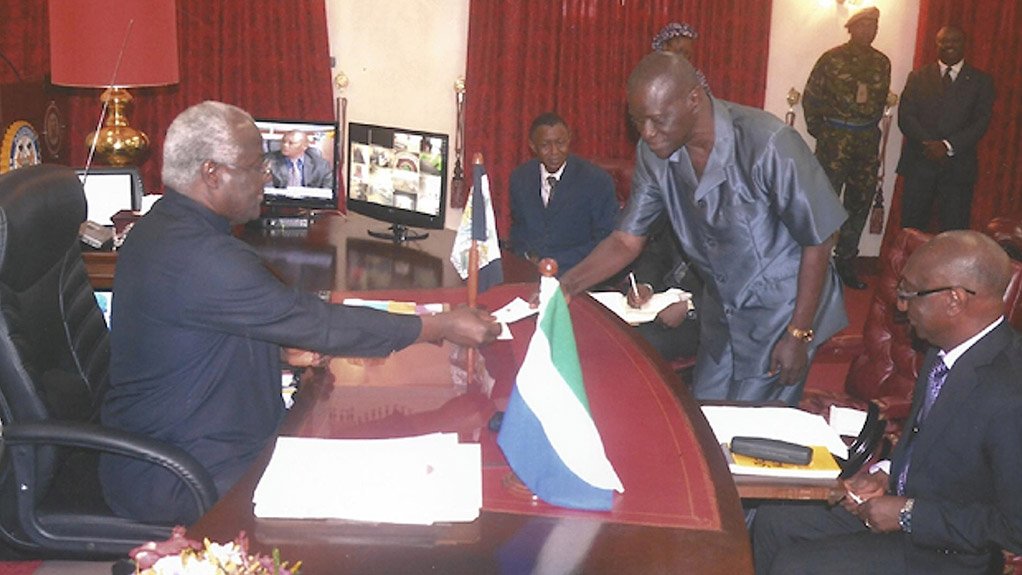 DONATING TO THE CAUSE Sierra Leone President Ernest Bai Koroma receiving a cheque from Golden Saint Resources local director Timothy Bangura to support the country’s efforts to eradicate Ebola 