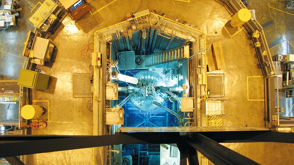 POOL TYPE A vertical view into the SAFARI-1 reactor today. The blue light shows that the reactor is in operation. The water in the pool is so clear as to be effectively invisible in this photo