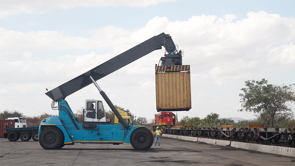 A reach stacker mobile crane loads a container onto a waiting train as part of a demonstration of the MIT facilities on Monday