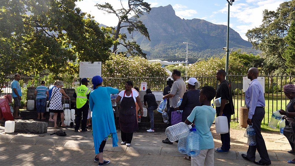 TRYING TIMES Capetonians queue up for fresh water at the Newlands Spring, alongside South African Breweries, in Cape Town