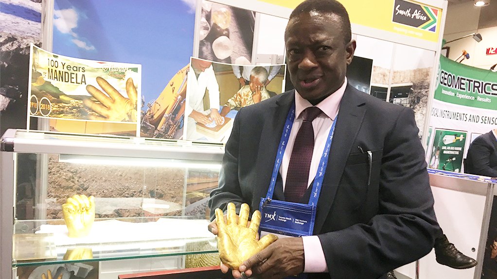 SA Deputy Mining Minister Godfrey Oliphant holds a gold casting of former President Nelson Mandela's hand during the 2018 PDAC convention, in Toronto