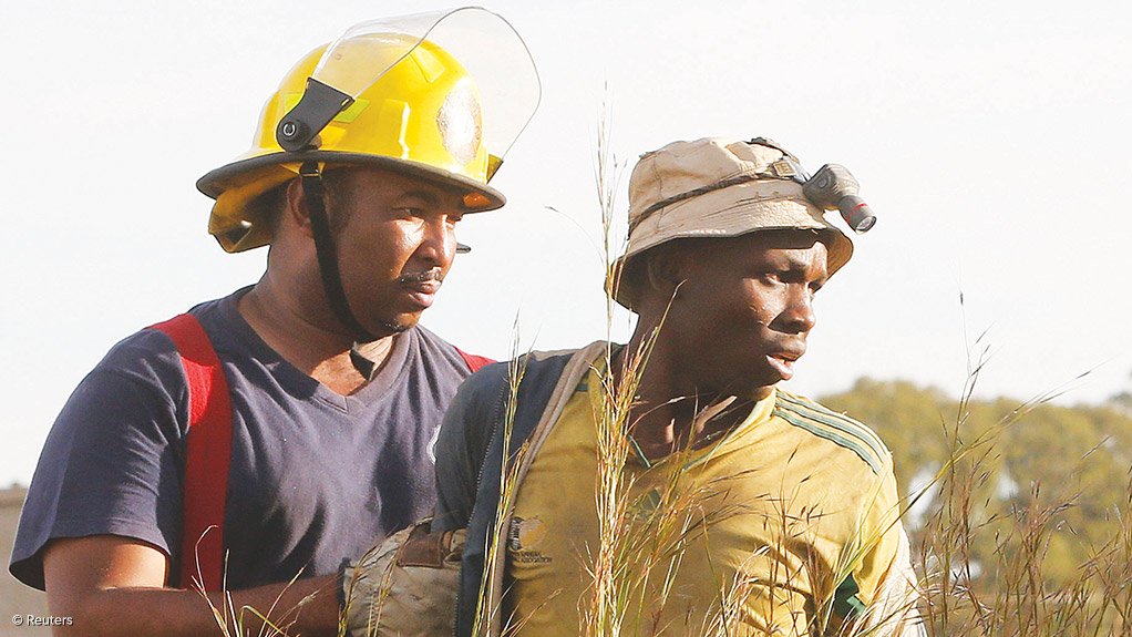 RISKING LIFE AND LIMB A suspected illegal miner is led away after being rescued from an abandoned gold mine shaft in Benoni, on the East Rand