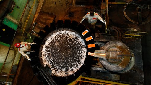 Workers pour molten silver into moulds