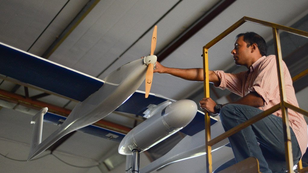 An unidentified CSIR research team member making adjustments to a CSIR-designed modular UAV