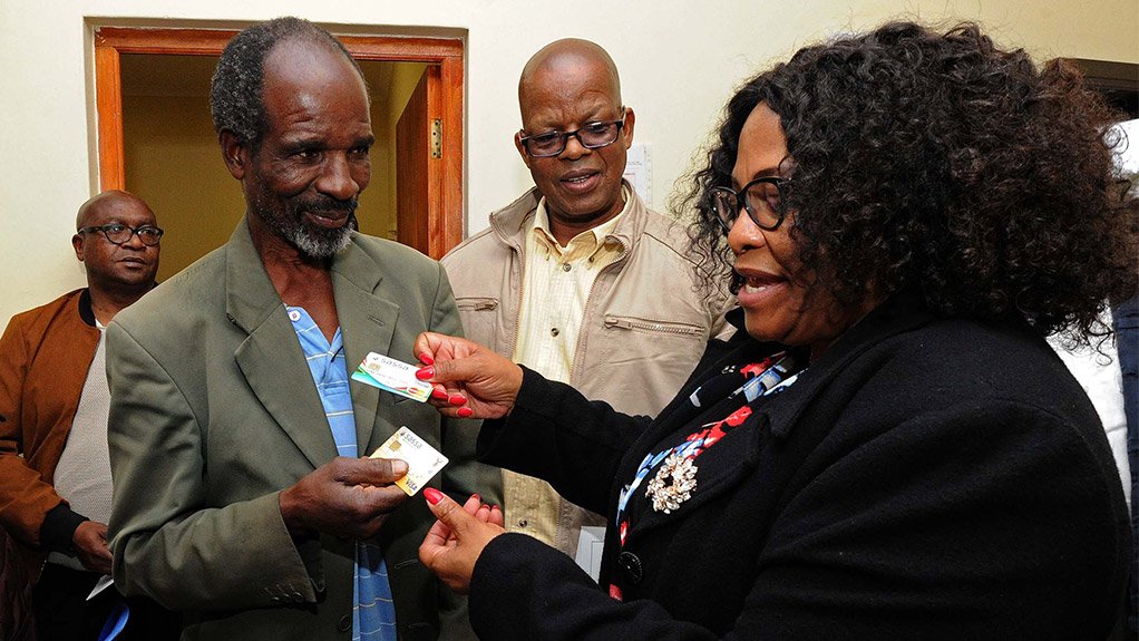 Communications Minister Nomvula Mokonyane handing over a new Sassa card to a pensioner 