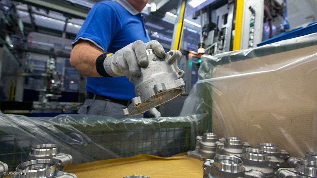 ON DUTY An employee holds a metal casing for an automotive steering system 
