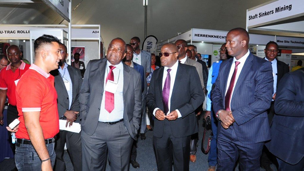 LEND ME AN EAR                                       An exhibitor presents his company to the Zambian Minister of Mines and Mineral Development Richard Musukwa and Zambian Minister of Commerce, Trade and Industry, Christopher Yaluma at CAMINEX 2018