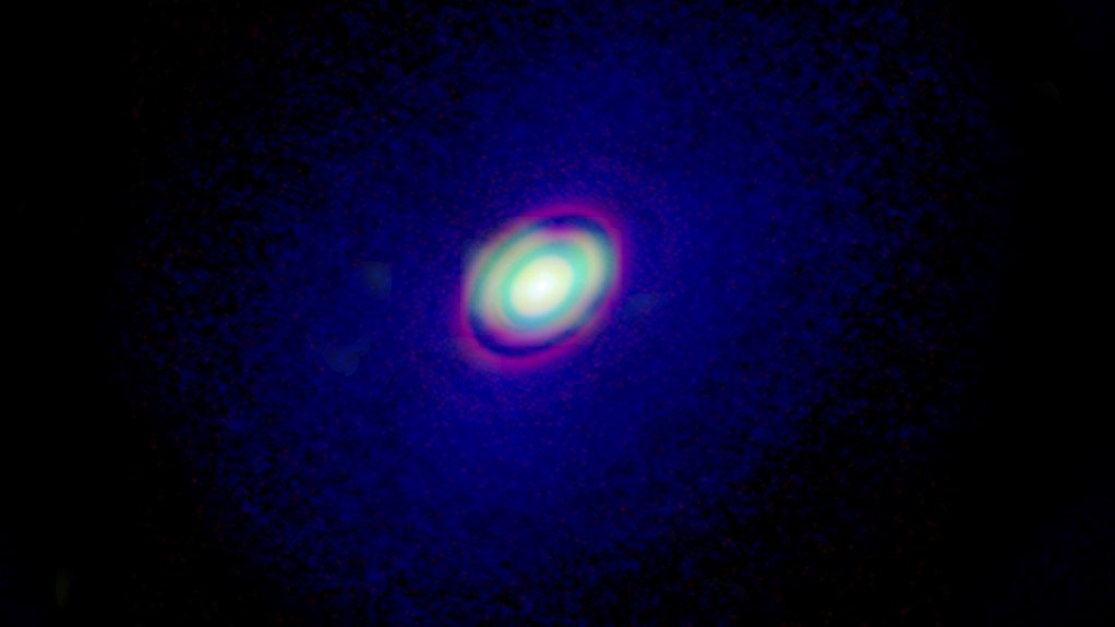 A composite image of HD 163296 and its encircling protoplanetary disc. The inner red regions show the dust in the disc, the inner green region represents the rare 13C17O, while the larger blue region shows the CO gas in the disc