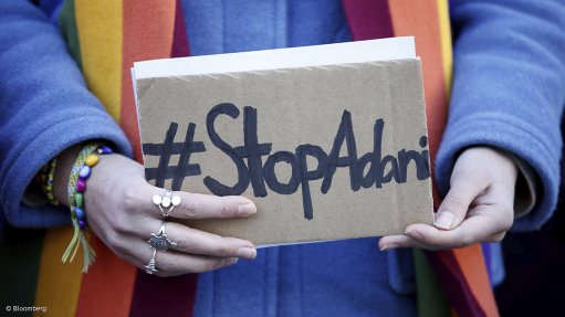 An activists from the Future environmental movement holds a placard reading '#Stop Adani' during a protest near the Siemens headquarters in Munich, Germany, on Friday.
