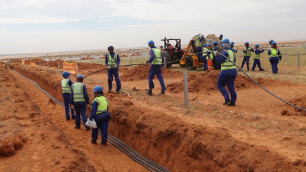  juwi workers on a solar PV farm construction site, complete their tasks in the correct gear, following strict safety protocols