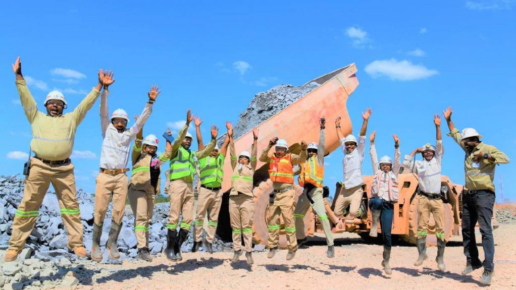 Members of Kamoa-Kakula’s multi-national team of geologists and engineers that is helping to build the Kakula mine, in front of the mine’s high-grade ore stockpile.