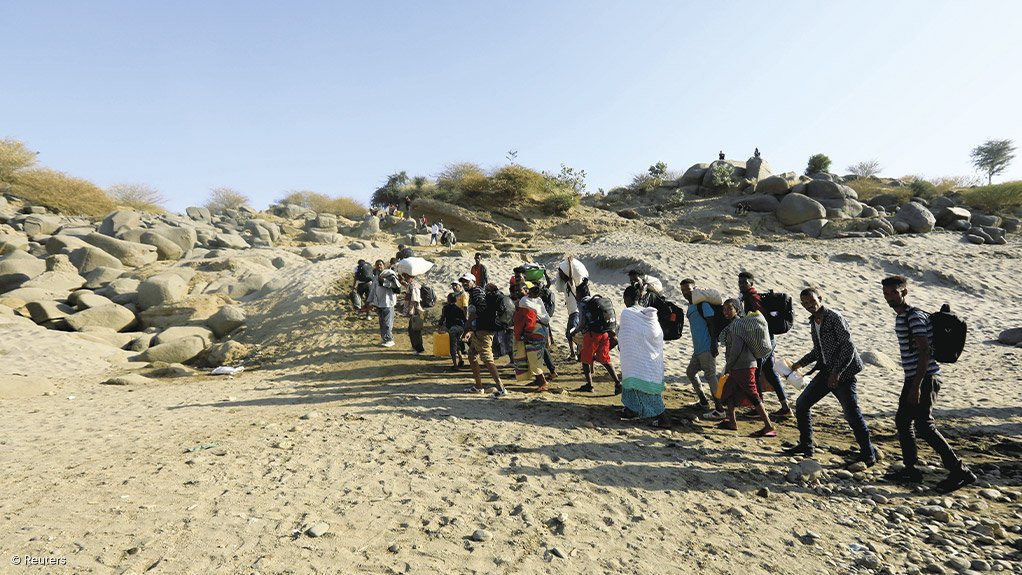 FLEEING CONFLICT: Ethiopians who fled the ongoing fighting in Tigray region, carry their belongings from a boat after crossing the Setit river on the Sudan-Ethiopia border in Hamdayet village in eastern Kassala state, Sudan. Ethiopian Prime Minister Abiy Ahme launched a military campaign against the Tigray People’s Liberation Front on November 4, accusing it of attacking two federal military camps in the northern region. Photograph: Mohamed Nureldin Abdallah for Reuters
