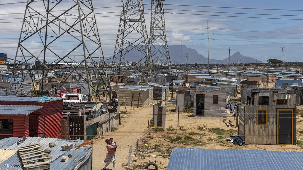 LOOMING LARGE: State-owned power utility Eskom has been warning for several months that the risk of load-shedding will loom as large as these power lines do over this Cape Town informal settlement. In its official planning, Eskom indicates that electricity shortages are possible during most weeks until April, after which the prognosis is expected to improve. The utility has also indicated previously that the risk of power cuts will be “significantly reduced, but not eliminated” only by September in line with progress being made under its so-called reliability maintenance programme. Photograph: Bloomberg
