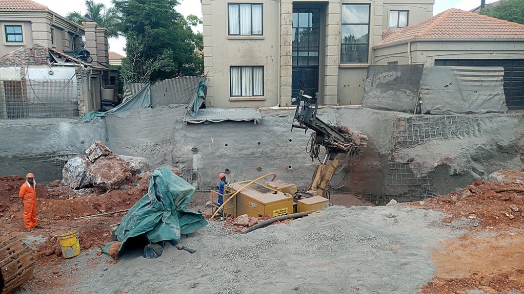 A general view of the enormous Irene sinkhole and adjacent residences, with large stabilising soil nails in place and Gauteng Pilling drilling taking place to add more.