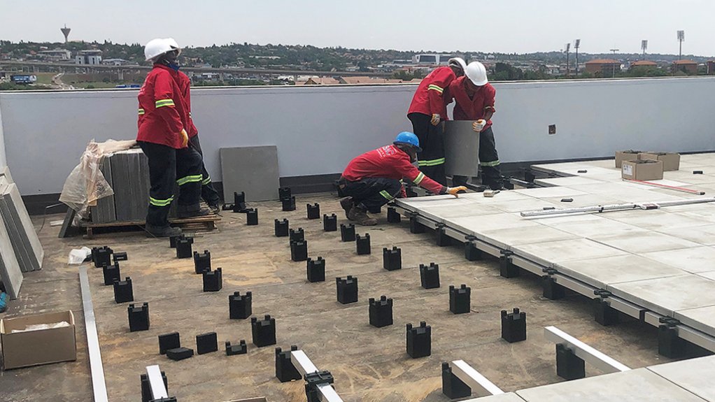 KBAC installers placing the concrete pavers on top of the InstaCradle rubber cradles made from recycled truck tyres for the balcony installation in Centurion.