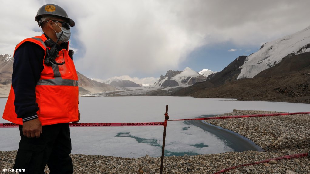 A worker stands on the bank of the lake near Petrov glacier, main water source for the Kumtor openpit gold mine, in Tien Shan mountains