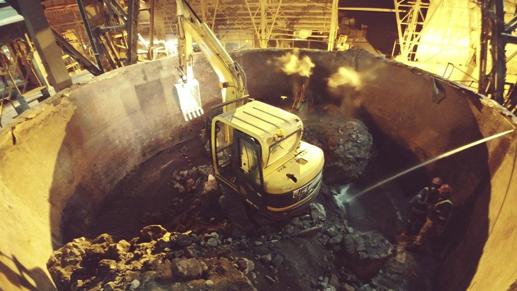 Mini excavator undertaking refractory demolition in a furnace 