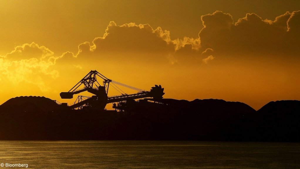An image of a coal stacker against the setting sun at the Newcastle port, in Australia.