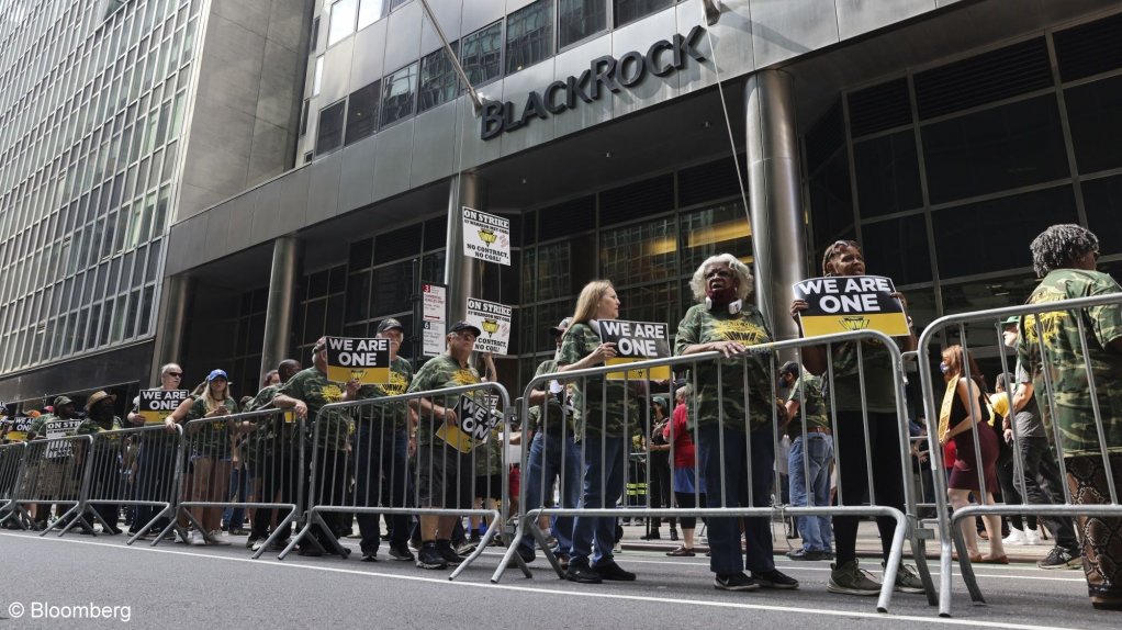 An image showing Members of the United Mine Workers of America picket during a strike against Alabama's Warrior Met Coal at the BlackRock offices in New York.