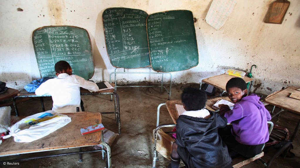 Picture of learners in a class with damaged infrastructure 