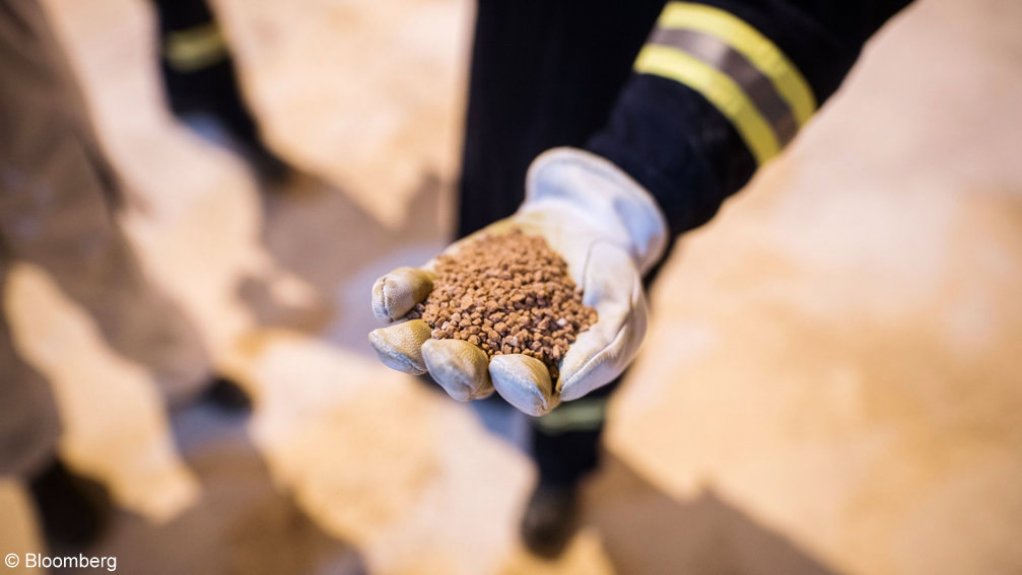An image of a person holding a handful of potash.
