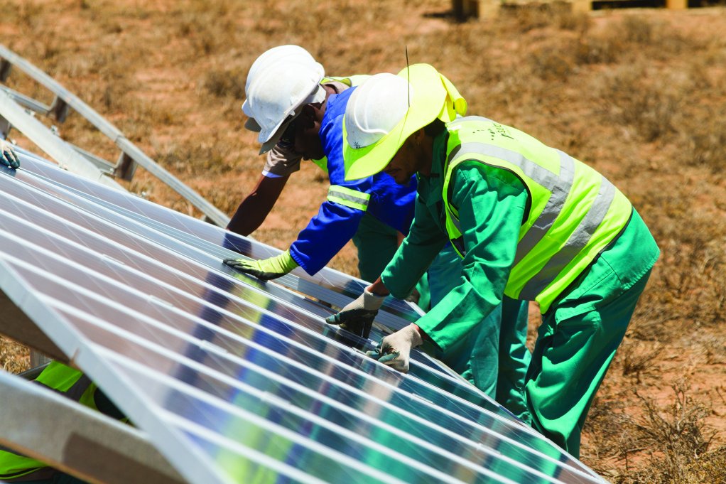 Workers installing solar panels at a project in South Africa