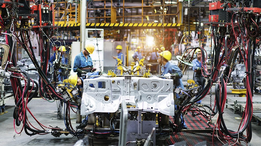 A photo of a high-tech automotive manufacturing facility and workers