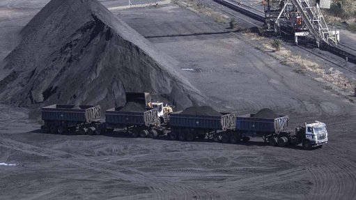 An image of a large Unitrans road train with four trailers being loaded with coal at a colliery 