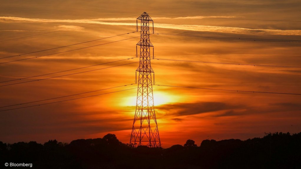 An image of an electricity pylon against the setting sun.
