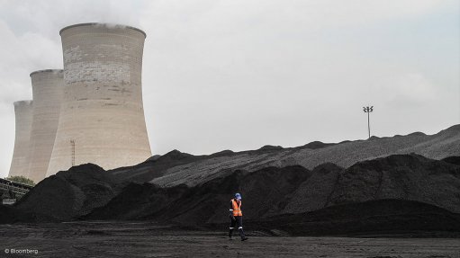 A photo of coal in front of a power station