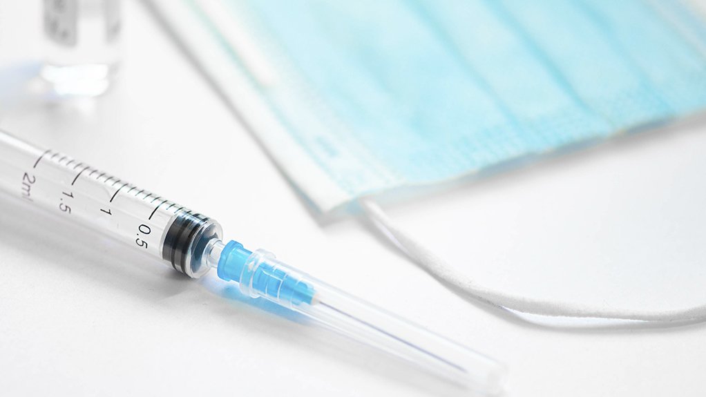 An image of a syringe with a needle and a medical face mask