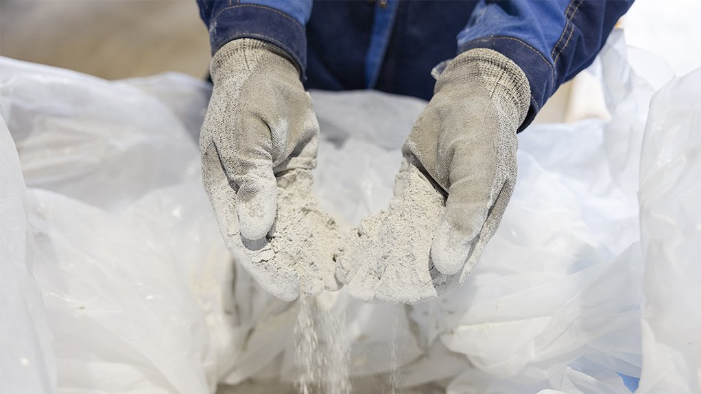 Image of gloved hands holding dry cement to illustrate that VTT and partners have developed a solution that could significantly reduce carbon dioxide emissions in the production of cement and quicklime