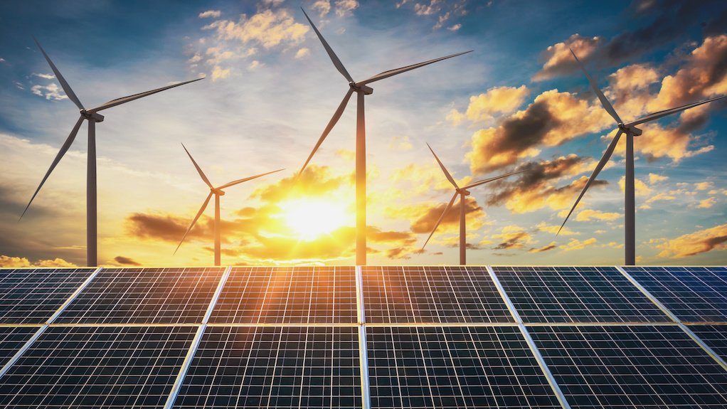 Image of wind turbines and solar panels at sunset
