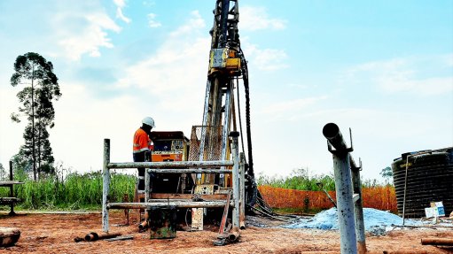 A core drilling rig at the Shanta Singida gold Project in Tanzania being operated by a man in PPE