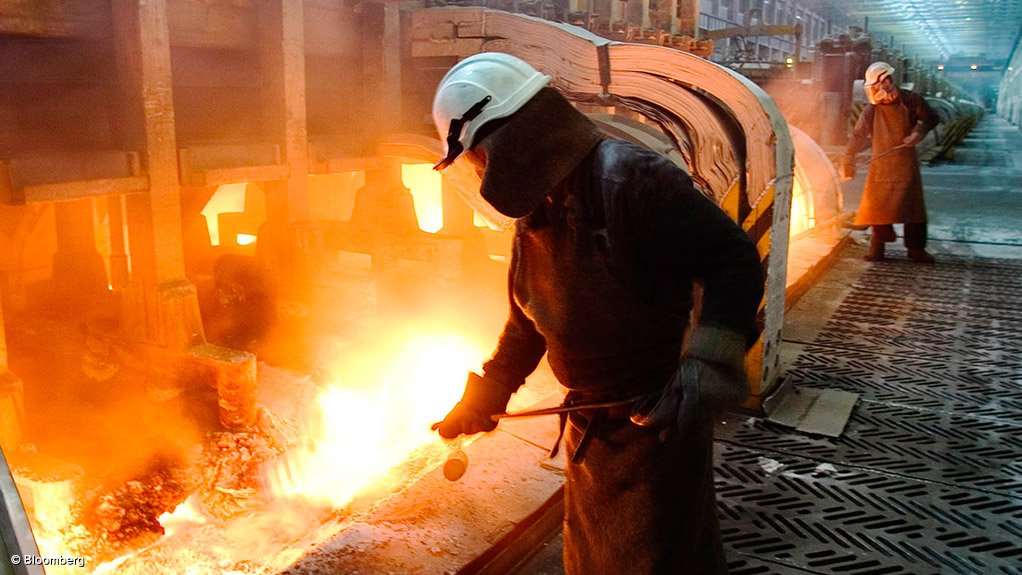 Image shows a worker at an aluminium smelter