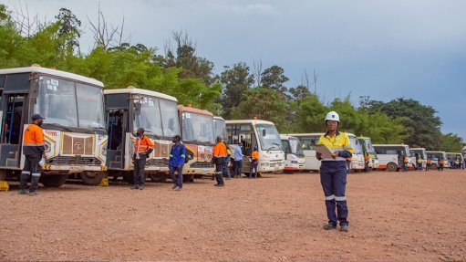 An image of employees waiting by a bus