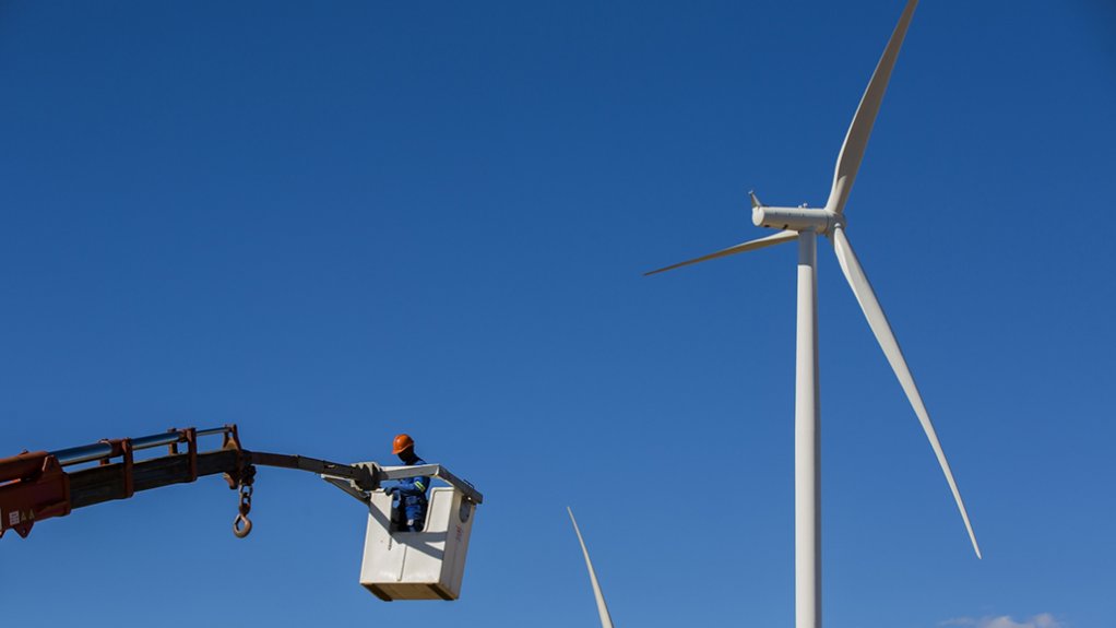 A photo of a wind turbine and a technician in a cherrypicker