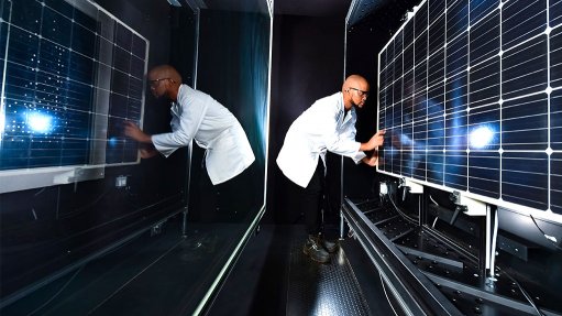 Image of a man wearing a white lab coat working in the CSIR's PV module reliability testing laboratory 