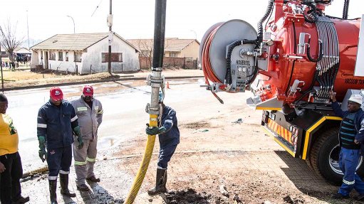 Municipality workers using a high pressure pumping unit to clean out sewers and drains to maintain municipal infrastructure