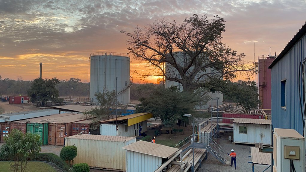 The sun setting in Mali behind a large generator installation alongside tanks, storage and other structures that comprise a minerals processing plant