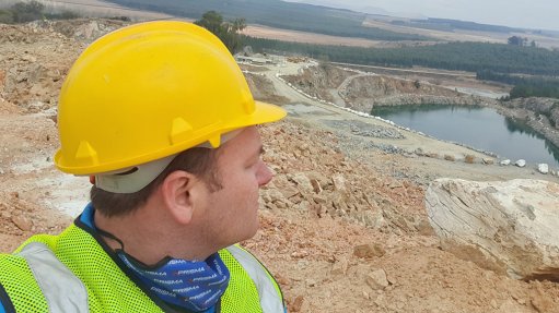 A picture fo Prisma Training MD Jacques Farmer Looking out onto an Open cast mine wearing PPE