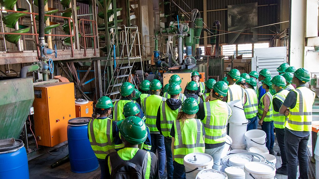 An image of a cohort of students in personal protective equipment standing in a Multotec facility receiving training 